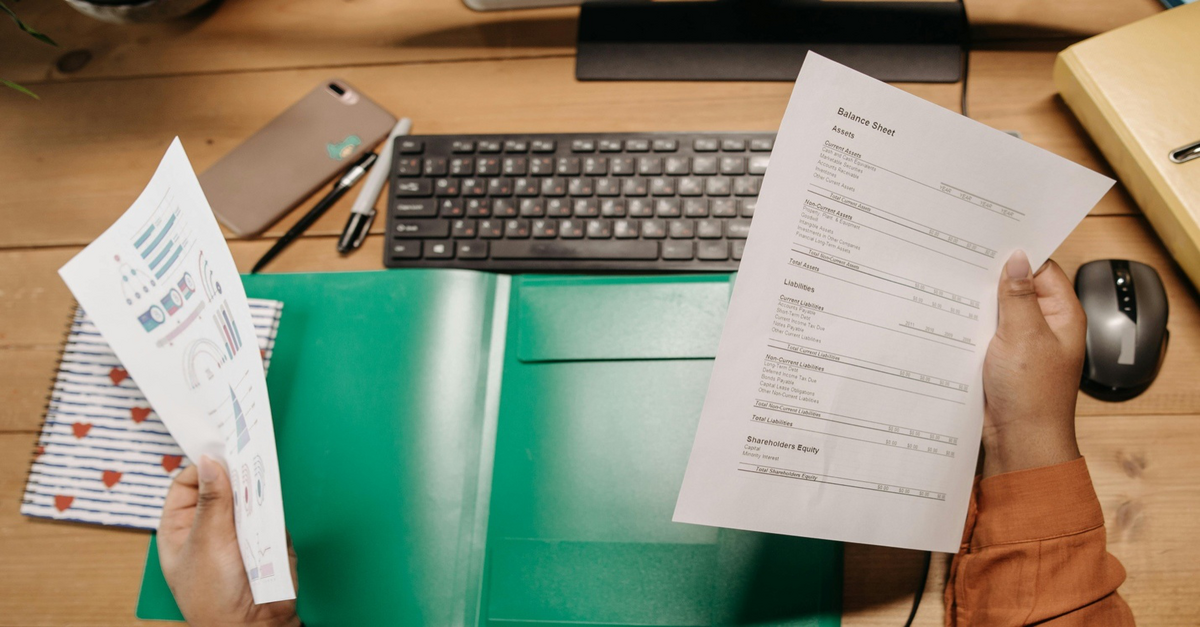 A person is holding financial documents