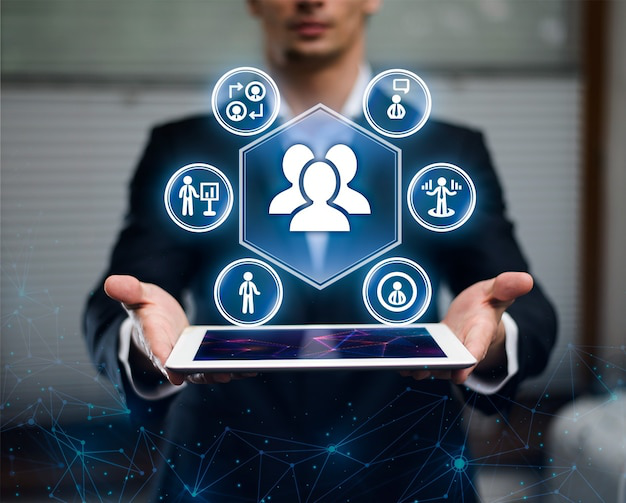 A man holding a tablet that shows various icons representing the concept of HRMS systems for businesses.