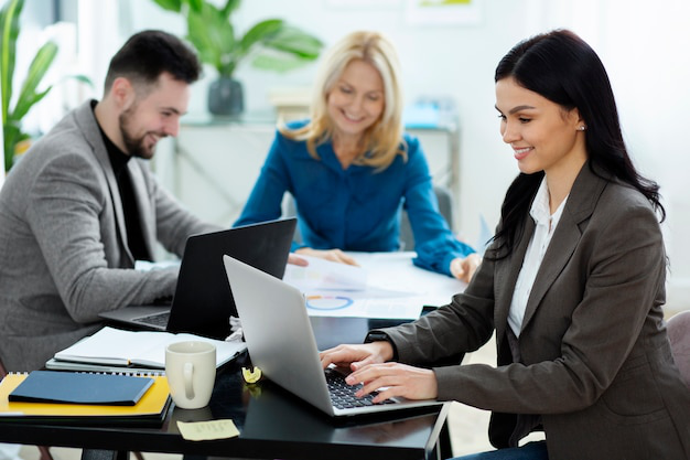 A diverse group of colleagues working together at a table in a relaxed and collaborative office environment.