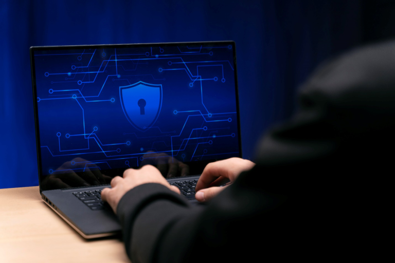 A laptop shows a lock and key symbol as a person’s hands are seen on the keyboard, highlighting the need for cyber security services as outlined in this Managed IT Services guide