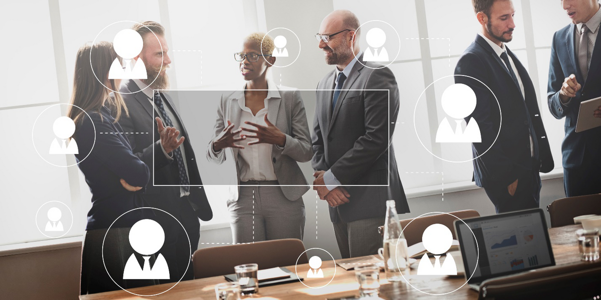 Professionals discussing workforce management strategies with digital network overlays in a conference room.