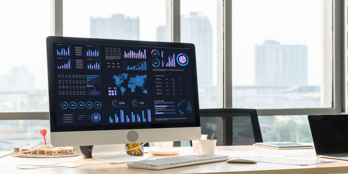 Business intelligence dashboard on a desktop monitor representing the modernization of legacy finance and operations systems