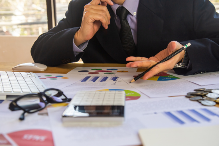 Close-up of a professional analyzing reports and data at a desk.