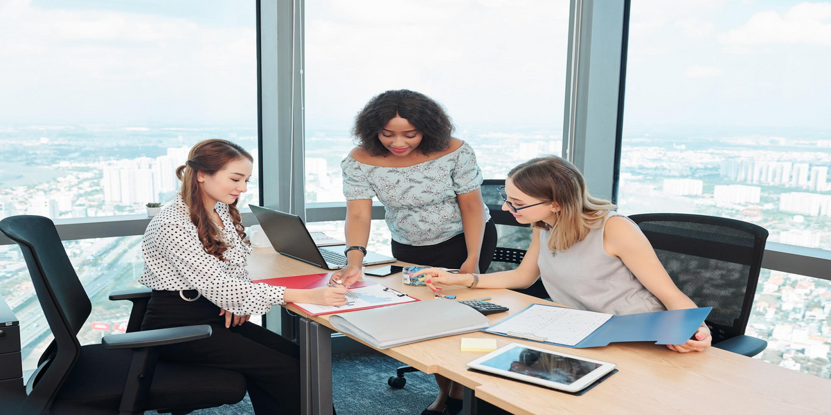 Finance leaders reviewing financial documents and dashboards during a strategy meeting, representing ERP-driven financial visibility and collaboration.