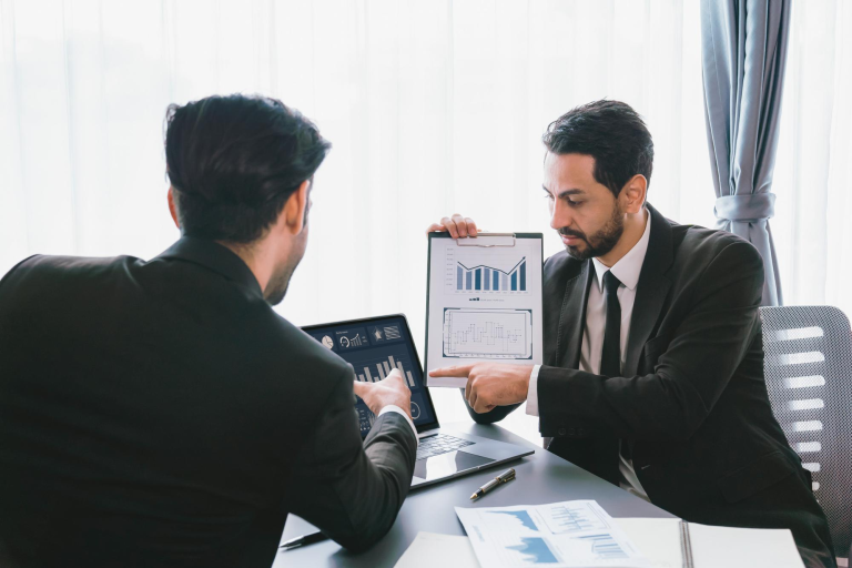 CFO presenting financial performance charts on a tablet during a business discussion, illustrating ERP analytics and reporting clarity.