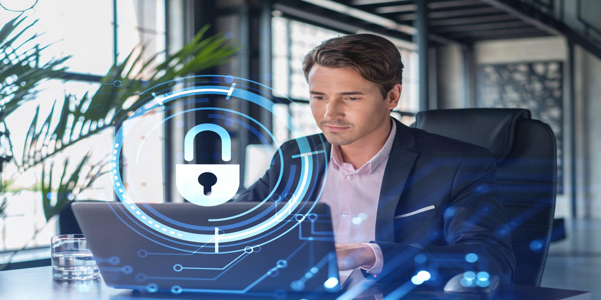 Businessman in a suit working on a laptop with a digital padlock graphic overlay.