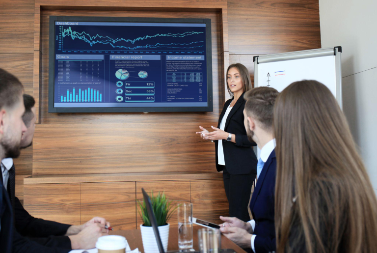 Team reviewing financial performance dashboards during a meeting, illustrating how AI-enhanced Sage Intacct ERP supports data-driven decision-making.