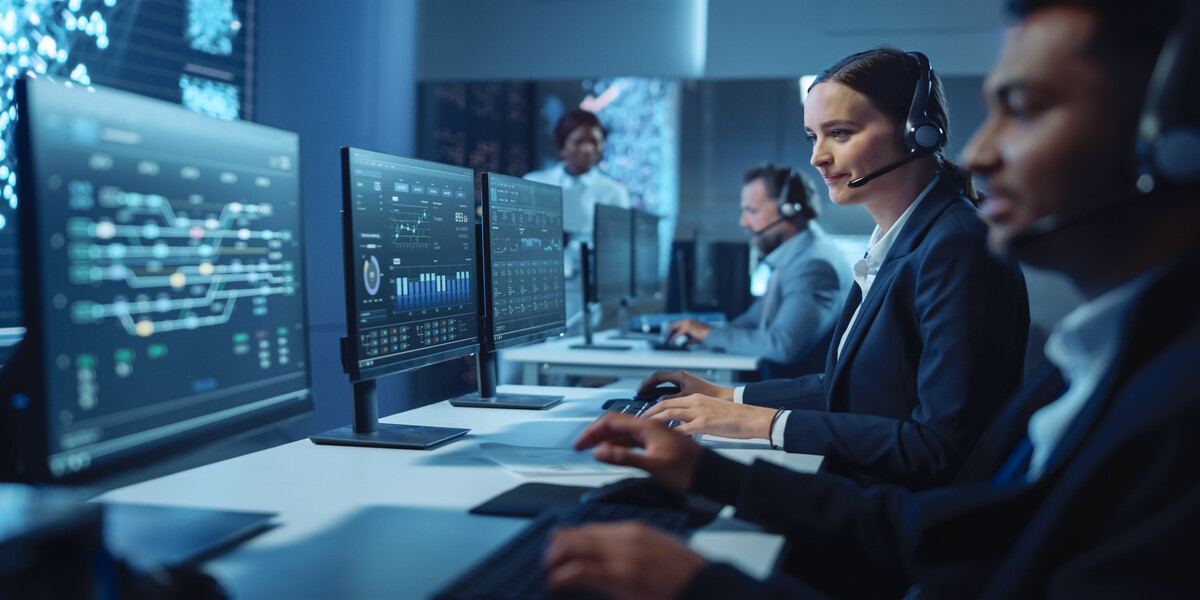 IT support team monitoring systems in a control room environment for hybrid business operations.