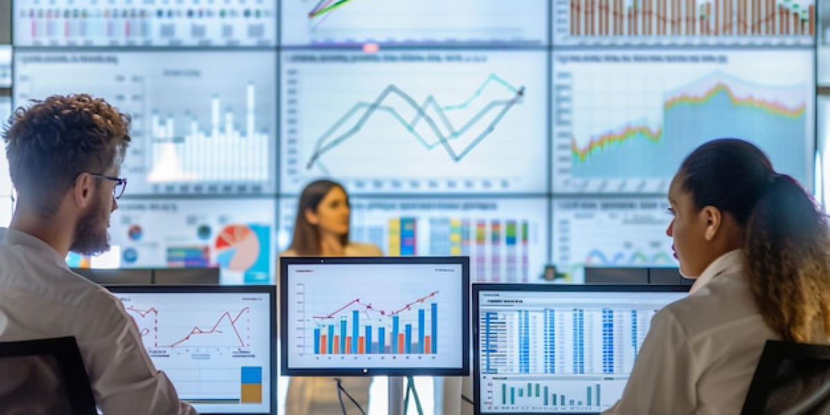 Team analyzing data on multiple monitors and large screens in an office.