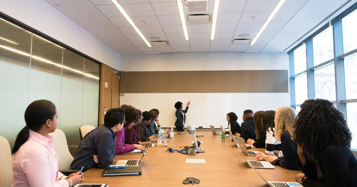 boardroom-meeting-Sage-consultants A boardroom meeting where one person presents while others use laptops, representing how growing businesses can make better decisions with Sage Intacct or Sage 300 ERP.