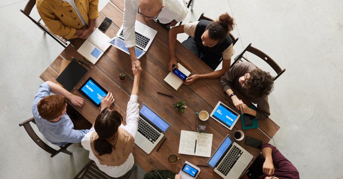 A group of people during a business meeting, two of them are shaking hands